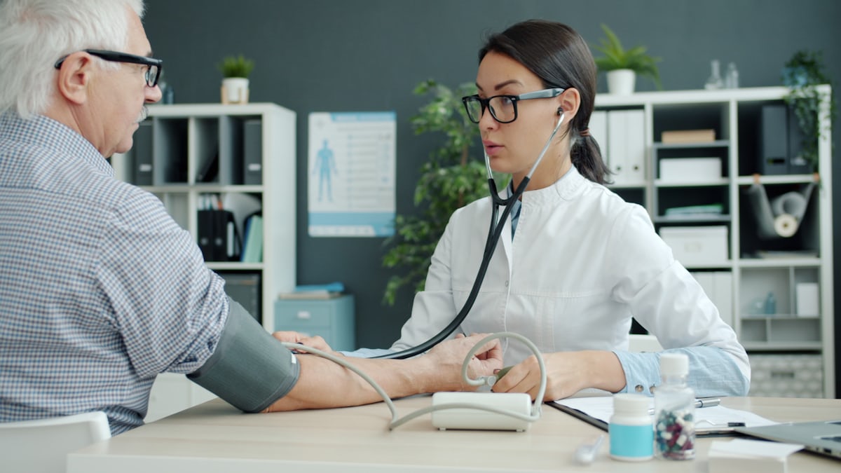 Doctor checking blood pressure and pulse during consultation